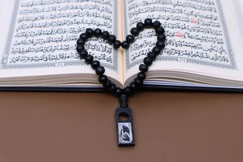 Prayer beads on top of the open Al Quran Stock Photos