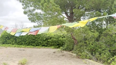 Prayer flags flutter in the wind at a buddhist monastery in garraf spain Stock Footage 311369774