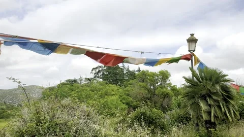 Prayer flags flutter in the wind at a buddhist monastery in garraf spain Stock Footage 311369858