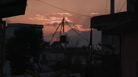 Prayer flags fluttering in the wind over the houses at sunset Stock-Footage 104432537