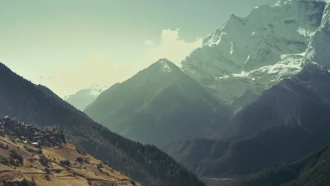 Prayer flags sway in wind in front of Annapurna II snow face nearby Ghyaru villa Stock Footage 294613666