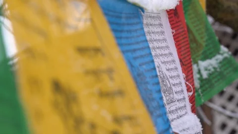 Prayer flags swaying under the snow . Shallow depth of field. Stock Footage 104658589