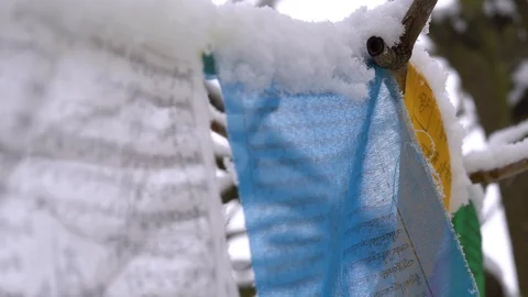 Prayer flags swaying under the snow . Shallow depth of field. Stock Footage 104660772