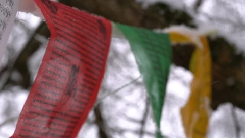 Prayer flags swaying under the snow . Shallow depth of field. Stock Footage 104661460