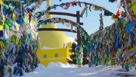 Prayer flags with tibetan mantras hang out in temple complex at cold winter Video stock 148044553