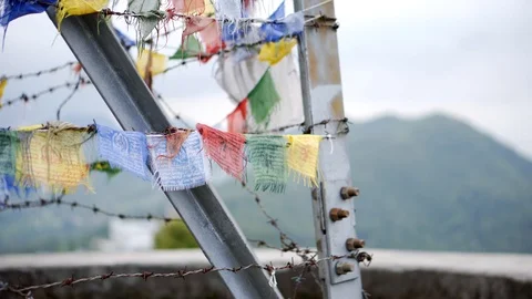 Prayer flags wrapped around barbed wire in Nepal Stock Footage 91171551