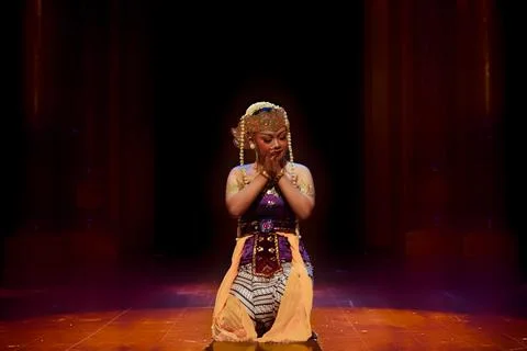 Prayer Pose of Traditional Dancer Beneath Warm Stage Lighting Stock Photos