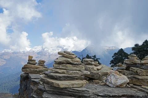 Prayer stone stacks with cloudy blue sky and snowy mountain view Stock Photos