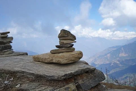 Prayer stone stacks with cloudy blue sky and snowy mountain view Stock Photos