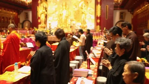 Prayers and tourists in Buddha Tooth Temple of Singapore Stockbeeldmateriaal 75426103
