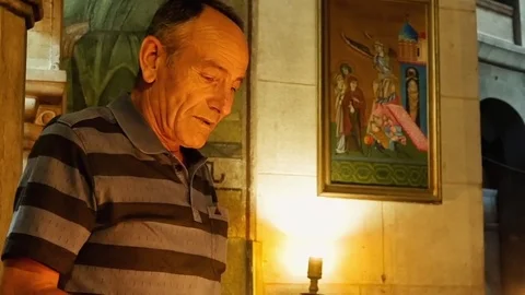 Prayers lighting candles in Holy Sepulcher Church Stock Footage 79392672