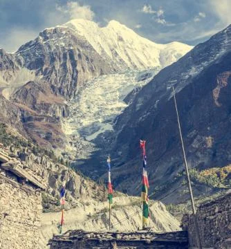 Praying flags blowing in the wind infront of a glacier. Stock Photos