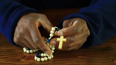 Praying to God with hand's together with cross and with people black background Stock Footage 333940193
