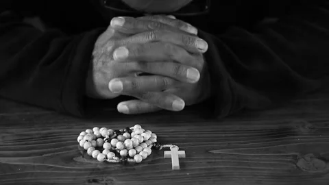 Praying to God with hand's together with cross and with people black background Stock Footage 334024058