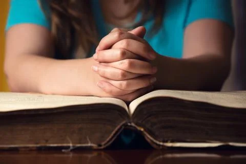 Praying hands on bible Stock Photos