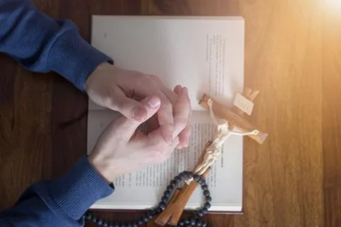 Praying hands with bible Stock Photos