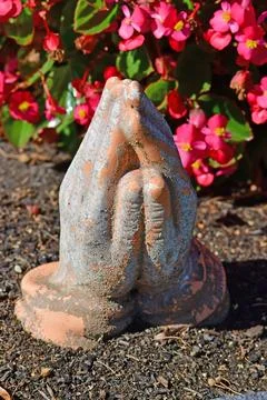 Praying hands on a grave Stock Photos