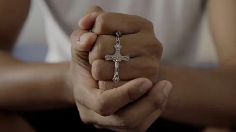 Praying hands holding silver crucifix close up Stock Footage 316613744