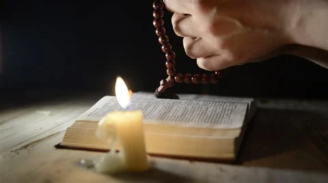 Praying hands over a holy book Stock-Footage 56942457