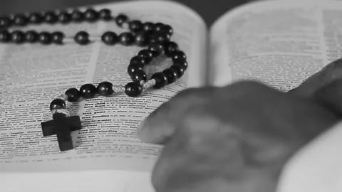 Praying with hands together with holy bible on table on white background with Stock Footage 321939902