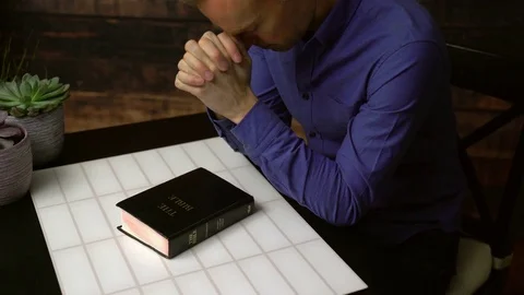 Praying man opens bible and reads Stock Footage 85449654