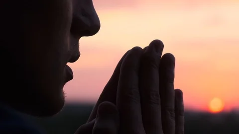 Praying man at sunset, close up Stock Footage 111196481