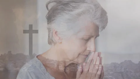 Praying over cross and rocky landscape animation, elderly woman showing devotion Video stock 304191663
