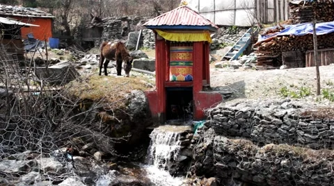 Praying wheel spinning by the stream of river Stock Footage 67647657
