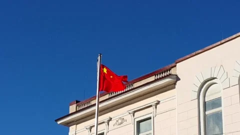 The PRC flag flutters in wind against cloudless sky. Stock Footage