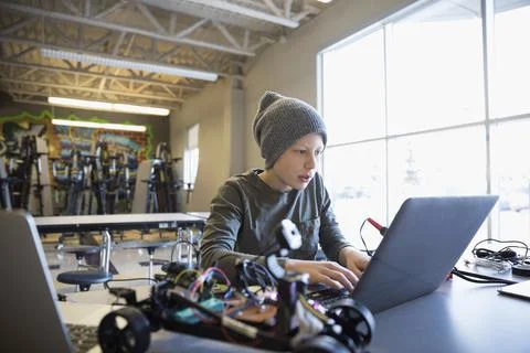 Pre-adolescent boy programming robotics at laptop in classroom 스톡 사진