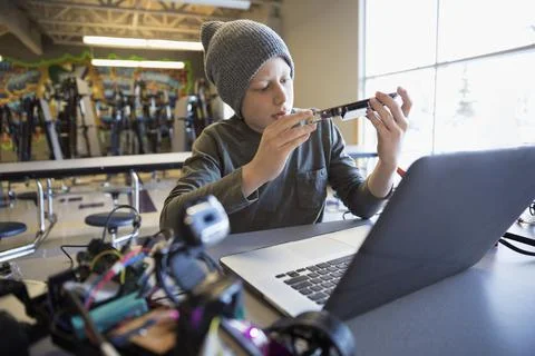 Pre-adolescent boy programming robotics at laptop in classroom 스톡 사진