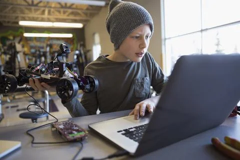 Pre-adolescent boy programming robotics at laptop in classroom 스톡 사진