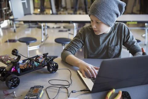 Pre-adolescent boy programming robotics at laptop in classroom 스톡 사진