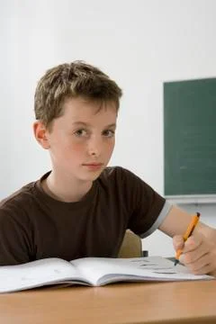 A pre-adolescent boy studying in a classroom Stock Photos