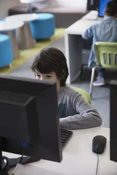 Pre-adolescent boy using computer in classroom Stock Photos