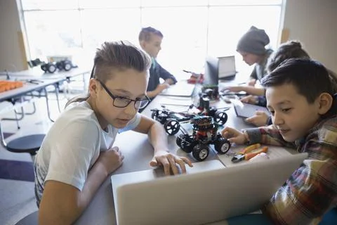 Pre-adolescent boys assembling and programming robotics at laptop in classroom 스톡 사진