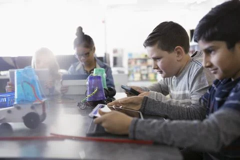 Pre-adolescent boys programming robotics at digital tablets in classroom 스톡 사진