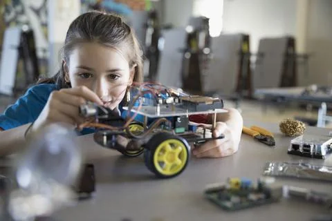 Pre-adolescent girl assembling robotics in classroom Foto stock