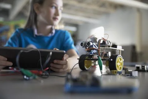 Pre-adolescent girl programming robotics at digital tablet in classroom 스톡 사진
