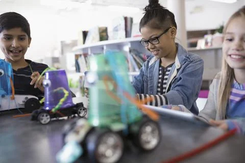 Pre-adolescent students programming robotics at digital tablets in library 스톡 사진