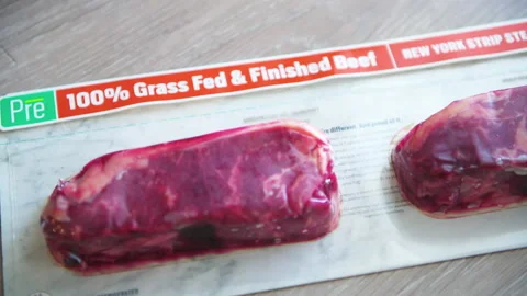 Pre brand of grass fed and finished beef New York strip two steaks Stock Footage 165300293