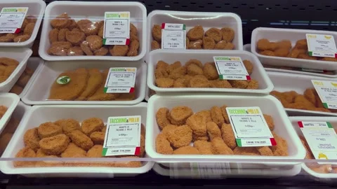 Pre-cooked chicken and turkey nuggets packed in plastic trays Stock Footage 284669229