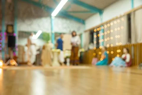 Pre-event setup in wellness hall with seated participants and staff arranging Stock Photos