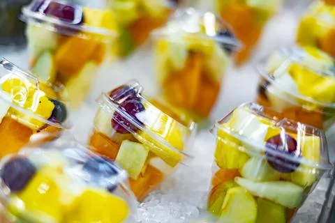 Pre-packaged fruit salads displayed in a commercial refrigerator Stock Photos