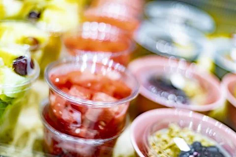Pre-packaged fruit salads displayed in a commercial refrigerator Stock Photos