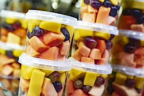Pre-packaged fruit salads displayed in a commercial refrigerator Foto stock