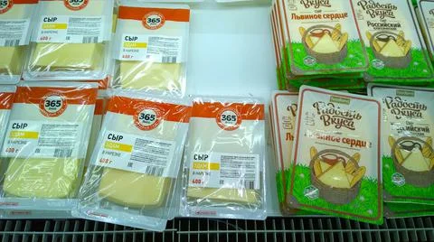 Pre-packaged portioning slicing cheese on supermarket shelf for customer. Foto stock