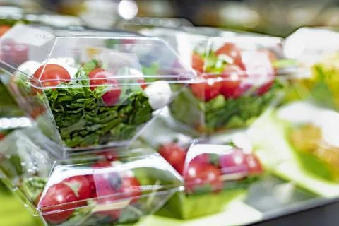 Pre-packaged vegetable salads displayed in a commercial refrigerator Stock Photos