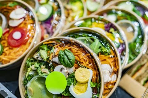 Pre-packaged vegetable salads displayed in a commercial refrigerator Stock Photos