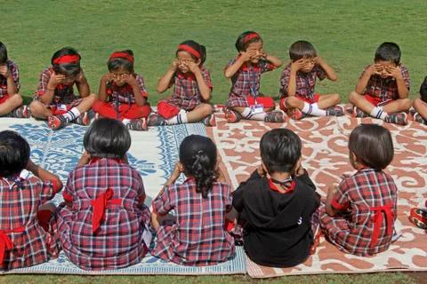 Pre primary students doing exercise on ground, india Stock Photos